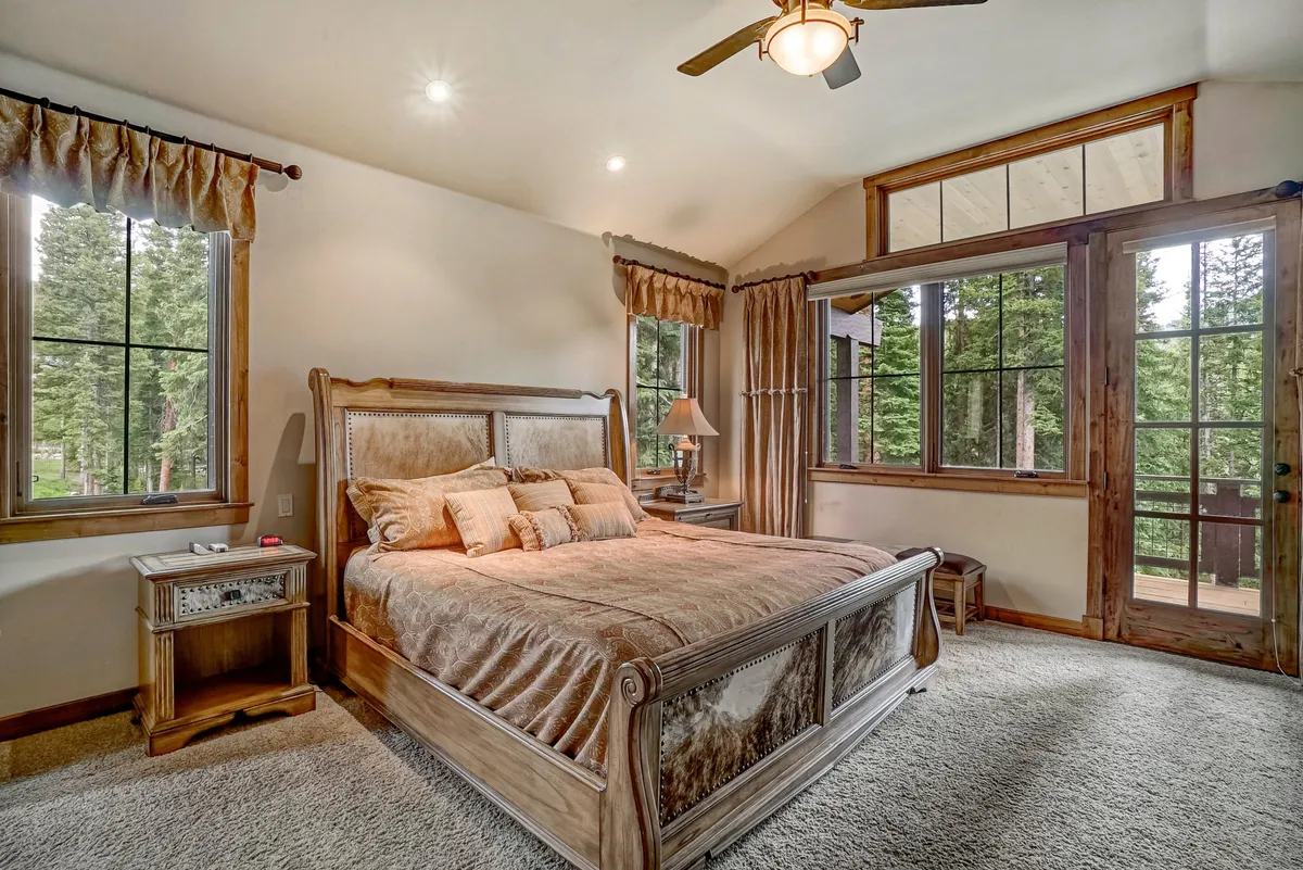 A peaceful bedroom with a comfortable bed, soft bedding, gentle lighting from bedside lamps, and large windows framing natural views. The minimalist style and organic color palette enhance the sense of serenity and privacy.
